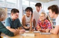 Teenagers in the school library are brainstorming together solving difficult problem