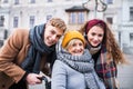 Teenagers and senior grandmother in wheelchair on the street in winter. Royalty Free Stock Photo