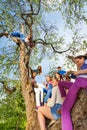 Teenagers sitting and holding mobiles on the tree