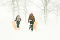 Teenagers with sleds in forest