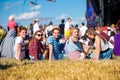 Teenagers, summer music festival, sitting in front of stage