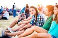 Teenagers at summer music festival, sitting on the ground Royalty Free Stock Photo
