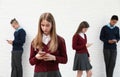 Teenagers using mobile phones at school. Concept of internet addiction