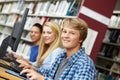 Teenagers working on computers in library