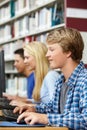 Teenagers working on computers in library