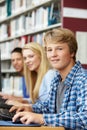 Teenagers working on computers in library