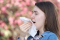 Teeneger girl with polen allergy sneezing in park Royalty Free Stock Photo