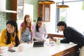 Teens collaborating on school project using tablet and smartphones in modern kitchen Royalty Free Stock Photo