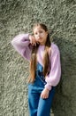 Teens girl posing against gray street wall