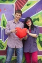 Teens with heart near graffiti wall. Royalty Free Stock Photo