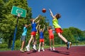 Teens in jump playing basketball game together Royalty Free Stock Photo