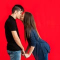 Teens kissing against red backdrop. Royalty Free Stock Photo