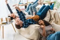 teens lying on sofa and taking selfie with tablet