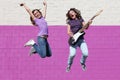 Teens playing guitar jumping Royalty Free Stock Photo