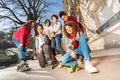 Teens with skateboard or rollerblades in cityscape Royalty Free Stock Photo