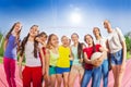 Teens stand in front of volleyball net, hold ball