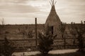 Teepee aka wigwam in the field with young trees. Vintage sepia toned image