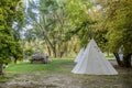 Teepee and cabin in forest of trees