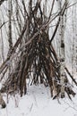 Teepee like structure made of fallen trees on a cold foggy morning at Assiniboine Forest in Winnipeg, Manitoba, Canada