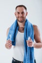 Teeth care. Man with blue towel stands against white background in the studio Royalty Free Stock Photo