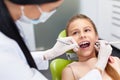 Teeth checkup at dentist's office. Dentist examining girls teeth