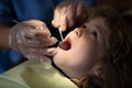 Teeth checkup at dentists, examining teeth close up. Dentist examining kids teeth in the dentists chair. Close-up