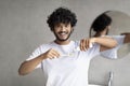 Teeth cleaning concept. Young indian man applying toothpaste on toothbrush, brushing teeth in bathroom in the morning Royalty Free Stock Photo