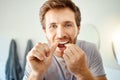 Teeth, dental floss and portrait of man in bathroom for self care, oral hygiene and morning routine. Cleaning, smile and Royalty Free Stock Photo