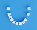 Teeth made of sugar cubes on blue background, some teeth missing. Sweet tooth dental health care concept Royalty Free Stock Photo