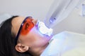 Teeth whitening on lamp ultravioleta. The girl on reception at the dentist for teeth whitening. The concept of dental care