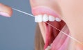 Teeths Flossing. Oral hygiene and health care. Smiling women use dental floss white healthy teeth. Dental flush - woman