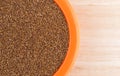 Teff grain filling a small bowl on wood table top