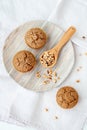 Teff hazelnut muffins on a plate with a scooper filled with hazelnuts.