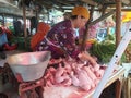 Tegal, May 2023. A photo portrait of a chicken seller in the market cutting up chickens to give to customers