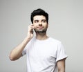 Tehnology, emotion and people concept: Smiling young man talking by smartphone