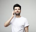 tehnology, emotion and people concept: Smiling young man talking by smartphone