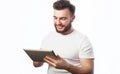 Tehnology, people and lifestyle concept: young bearded man wearing white t-shirt using a tablet computer Royalty Free Stock Photo