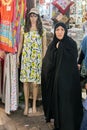 Woman in chador near mannequin wearing short dress, Tehran, Iran