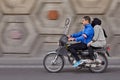 Married couple riding motorcycle on speedway, panning for motion