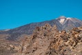Teide and layered volcanic rock in desert landscape and blue sky