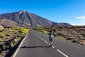 Teide - Woman standing on scenic mountain road leading to volcano Pico del Teide, Mount El Teide National Park, Tenerife