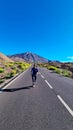 Teide - Woman standing on scenic mountain road leading to volcano Pico del Teide, Mount El Teide National Park, Tenerife
