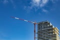 Red and white building crane on the construction of a modern high-rise building at the Royalty Free Stock Photo