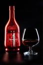 A bottle of French cognac Hennessy V.S.O.P with a glass of cognac isolated on a black background. Royalty Free Stock Photo