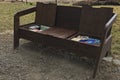 Close-up view of empty wooden a bench with open boxes with different books for reading