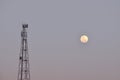 Telco transmission relay tower and moon in evening Royalty Free Stock Photo
