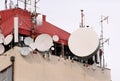 Telecommunication base stations network repeaters on the roof of building. The cellular communication aerial on city building roof Royalty Free Stock Photo