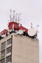 Telecommunication base stations network repeaters on the roof of building. The cellular communication aerial on city building roof Royalty Free Stock Photo