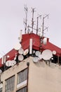 Telecommunication base stations network repeaters on the roof of building. The cellular communication aerial on city building roof Royalty Free Stock Photo