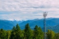 Telecommunication cell tower in the wild forest with mountain background, Altay